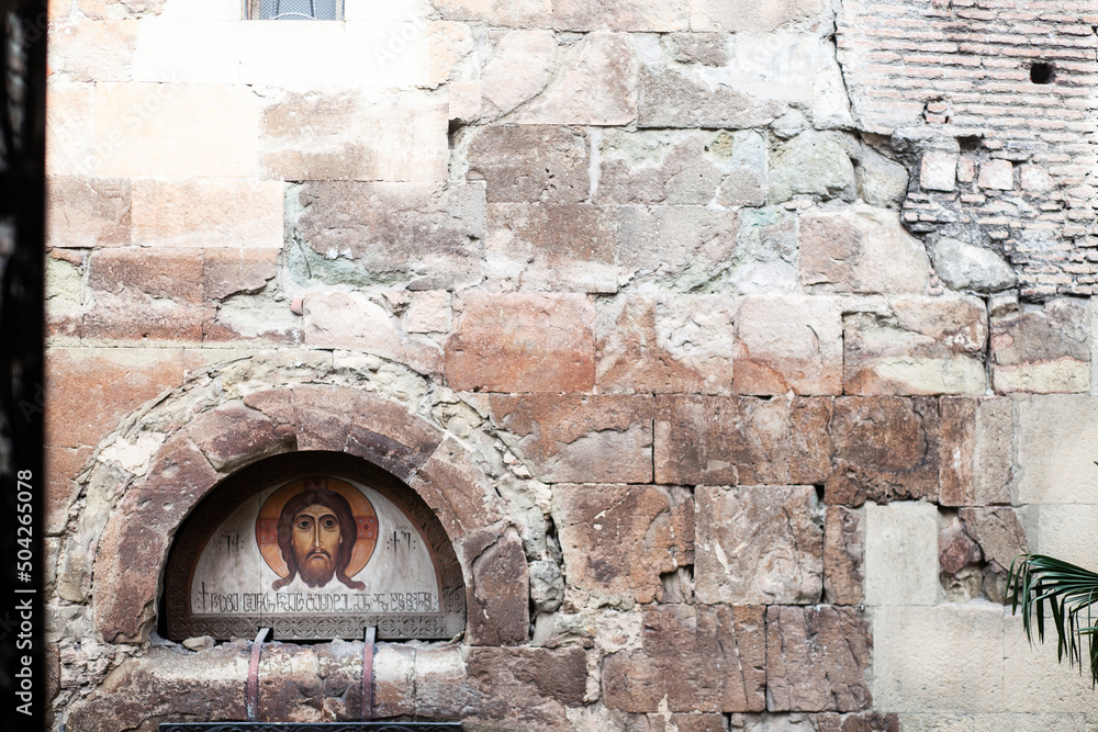 icon in the masonry of the wall on part of the facade of the church in ancient light close-up front view icon in the masonry of the wall on part of the facade of the church in ancient light close-up front view
