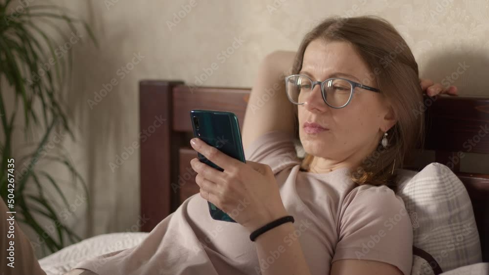 A young woman is relaxing with a phone on the couch. A young woman is relaxing with a phone on the couch.