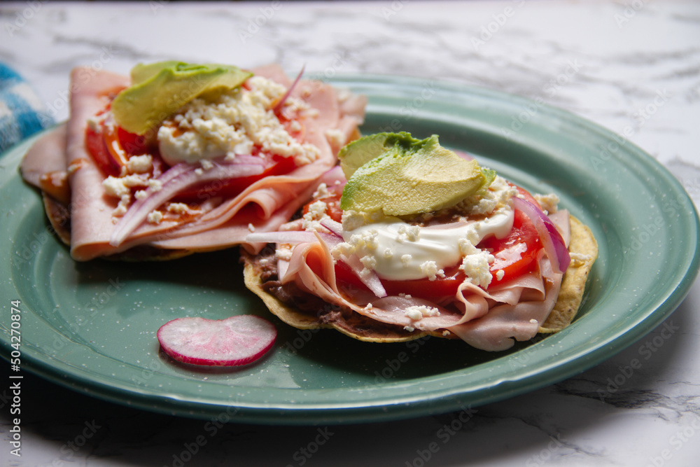 Ham tostadas with cheese and avocado. Mexican food