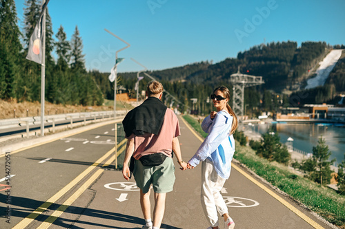Fototapeta Naklejka Na Ścianę i Meble -  Beautiful couple of stylish people on a summer mountain walk at the resort.