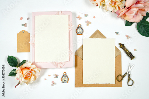 Vintage Theme Wedding Stationery Suite Mockup. Styled with handcrafted paper, blush pink vintage accessories, and natural Kraft paper envelopes. Two 5 x 7 Invitation cards.