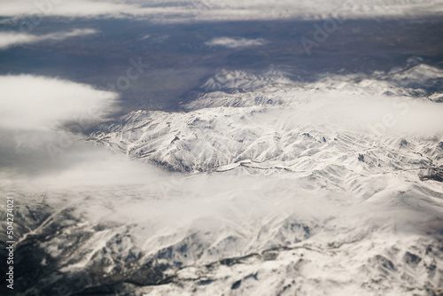 Aerial view of snowy mountains with clouds