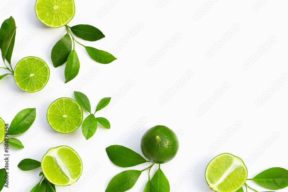 Fresh limes with green leaves on white background.