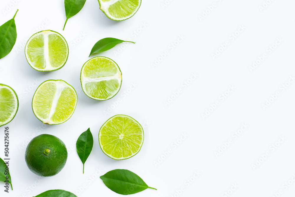 Fresh limes with green leaves on white background.