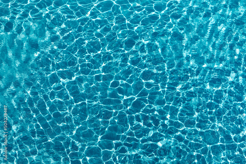Beautiful blue crystal clear water texture with small ripples on the surface.