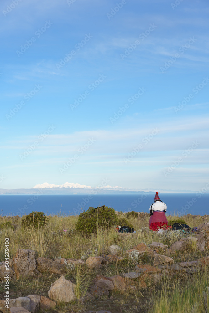 Mujer con traje tradicional mirando el lago Titicaca Mujer con traje tradicional mirando el lago Titicaca