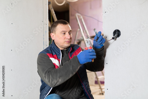Repairman cutting wires with pliers in domestic interior closeup © JackF
