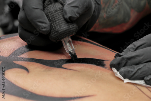 Tatuador en sesi  n de tatuaje tatuando un tatuaje a una persona