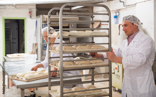 Man and woman prepare bread in the kitchen of the bakery. High quality photo