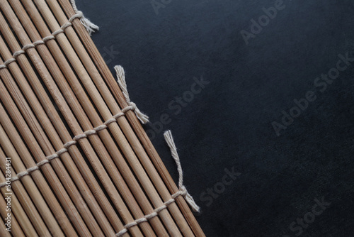 The cooking bamboo mat on the black table