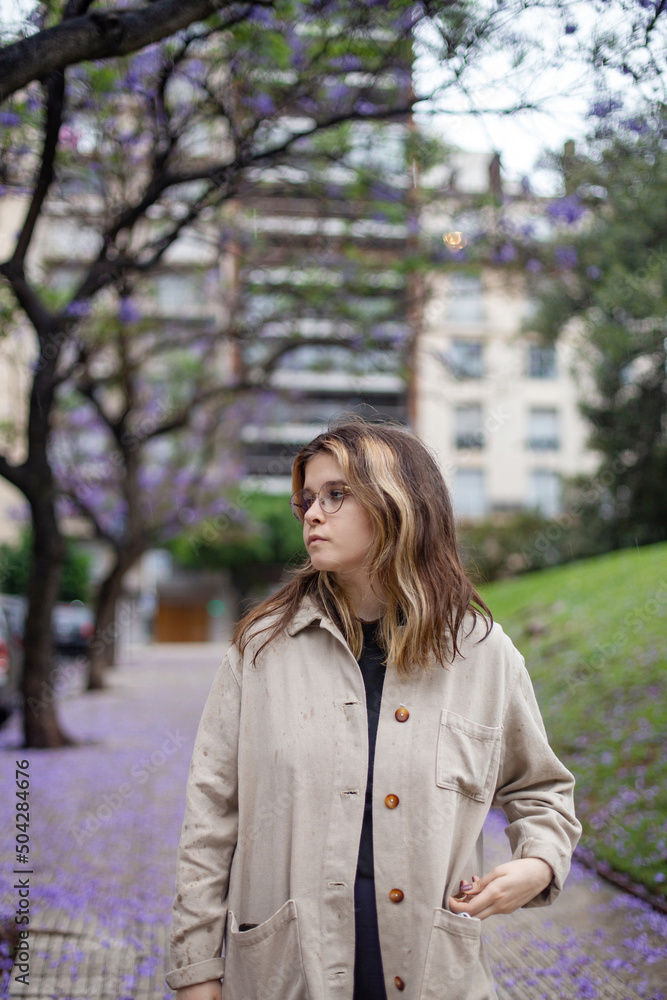 Pretty girl in glasses against the background of flowering trees in the city of Buenos Aires On a rainy day Pretty girl in glasses against the background of flowering trees in the city of Buenos Aires On a rainy day