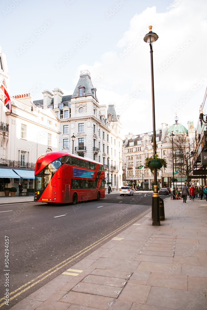 A red modern double decker bus travels through downtown London, Great Britain. 