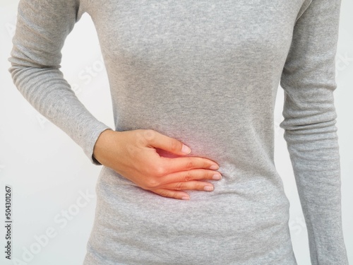 Woman with stomach pain causes of abdominal pain include inflammatory bowel disease-IBD. stomach ulcer irritable bowel syndrome (IBS), ulcerative colitis and microvilli. closeup photo, blurred. photo
