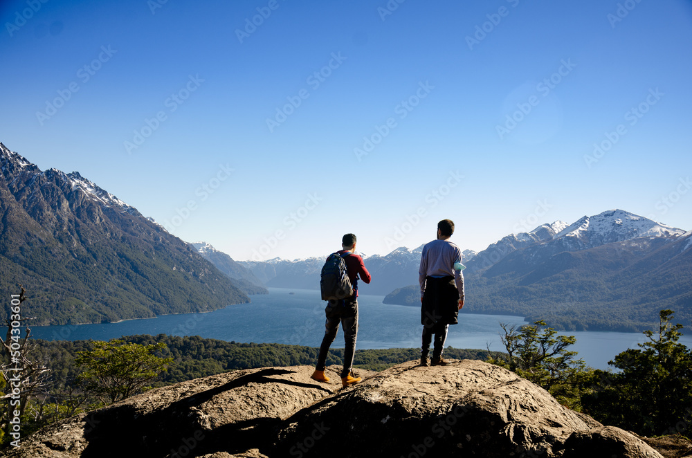 amigos sobre una roca en la cima de un cerro mirando el paisaje de ...