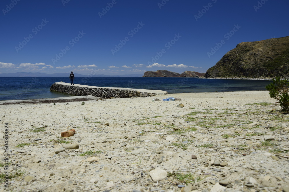 Obraz premium The man on the stone pier on Isla Del Sol (Island of the Sun) on the Titicaca lake. Bolivia.