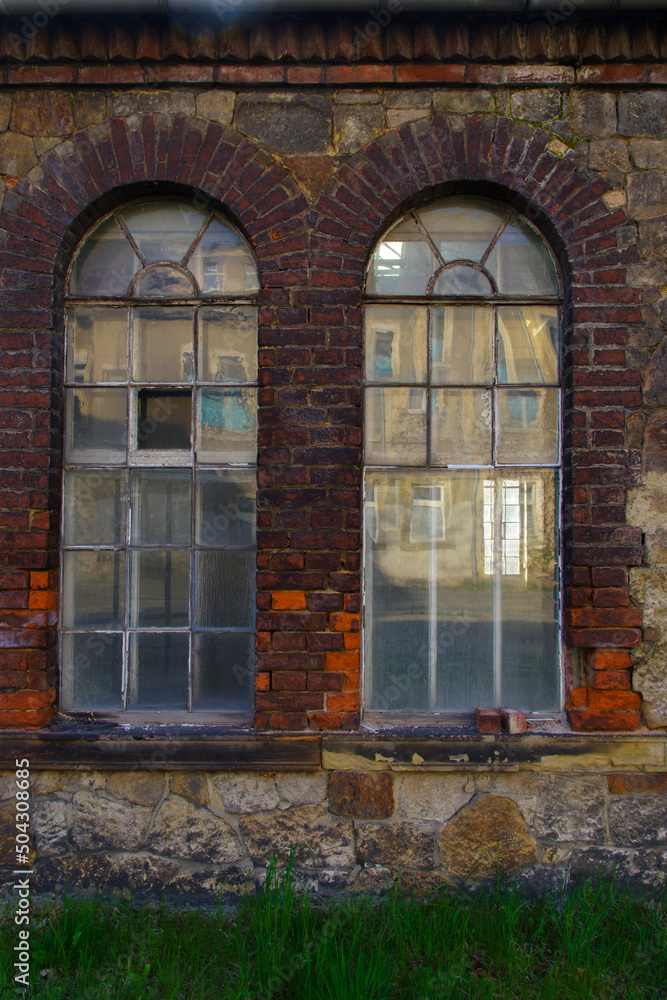 windows and red brick facade of old abandoned factory building in Germany