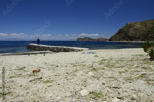The man on the stone pier on Isla Del Sol (Island of the Sun) on the Titicaca lake. Bolivia.