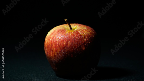 red apple on black background image captured at night 9 p.m. from well known restaurant in india.