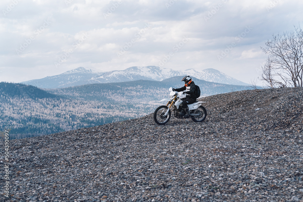 Off-road motorcycle driver riding on top of mountain