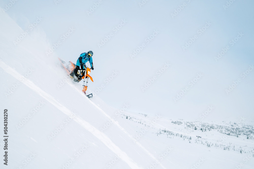 Winter sport outdoor. Male motorcyclist going down steep snowy slope riding snowbike dirt motorcycle