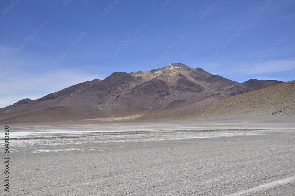 Lake between the mountains, with pink flamingo. Off-road tour on the salt flat Salar de Uyuni in Bolivia