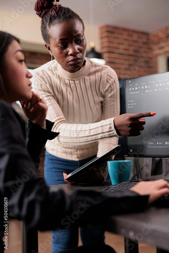 African american software developer pointing out cloud database processing algorithm error. Cybernetics engineers deciphering stolen corrupted and ecrypted important company files.