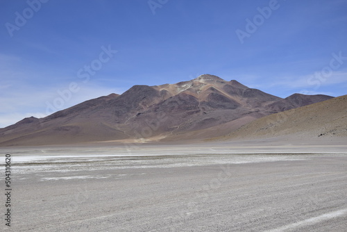 Lake between the mountains  with pink flamingo. Off-road tour on the salt flat Salar de Uyuni in Bolivia