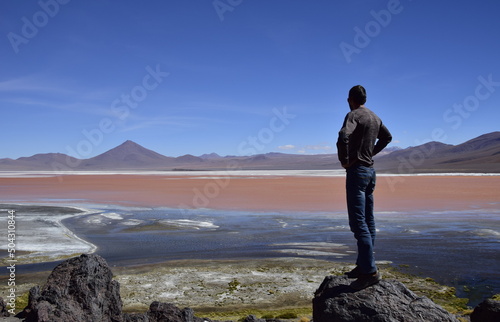 Bild auf Leinwand The man on the stone looks at Laguna Colorada, on Eduardo Avaroa