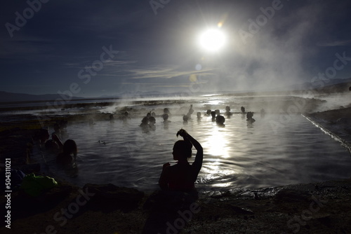 Uyuni, Bolivia - 10 february 2017: Tourists swim in a hot spring at sunrise in Eduardo Avaroa National Reserve in Uyuni photo