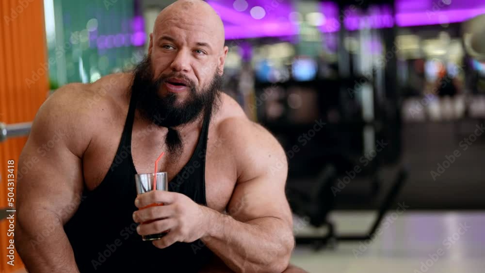A sporty man with a juice cocktail relaxes, enjoying a morning