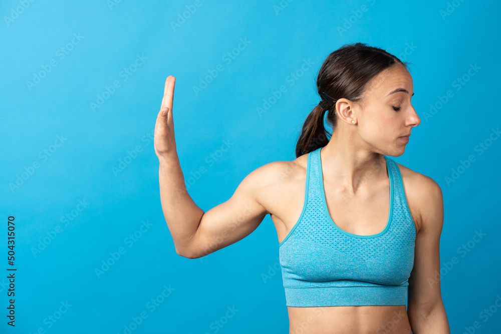 Negative fit woman rejecting temptations or problems isolated on blue background. Negative fit woman rejecting temptations or problems isolated on blue background.
