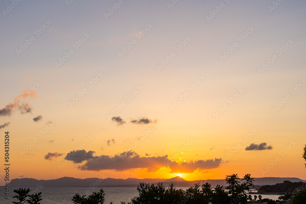 Early morning sunrise over the sea . Some clouds.