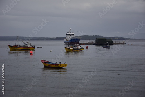 QUELLON, CHILE. Colourful fishing boats in the coastal town of Quellon on the island of Chiloe in Chile