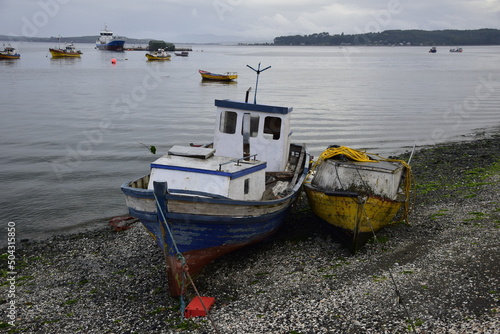 QUELLON, CHILE. Colourful fishing boats in the coastal town of Quellon on the island of Chiloe in Chile photo