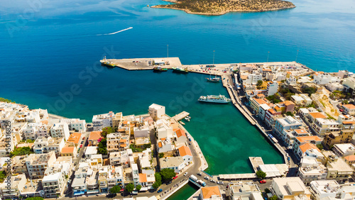 Agios Nikolaos. Agios Nikolaos is a picturesque town in the eastern part of the island Crete built on the northwest side of the peaceful bay of Mirabello.