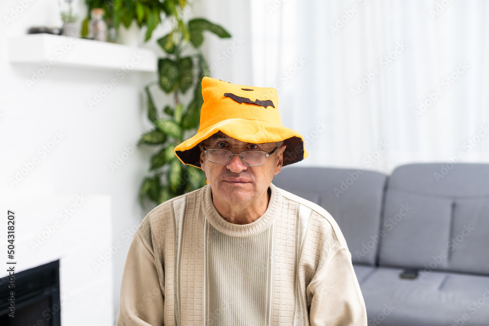 elderly sad man celebrating halloween at home. elderly sad man celebrating halloween at home.