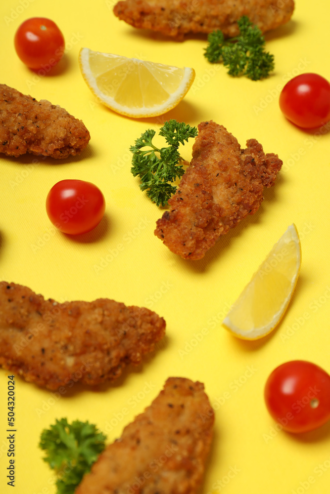 Concept of tasty food with chicken strips on yellow background Concept of tasty food with chicken strips on yellow background