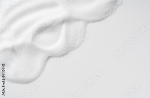 Skincare cleanser foam texture. Copy space and soap bubbles on white background.