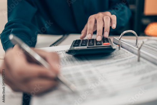 Investors working on desk office and using a calculator to calculate balance, projit, currency and cost. Accounting and Financial concept.