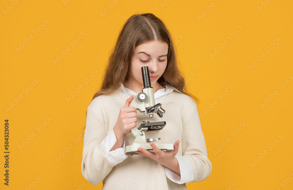 serious child with microscope on yellow background serious child with microscope on yellow background