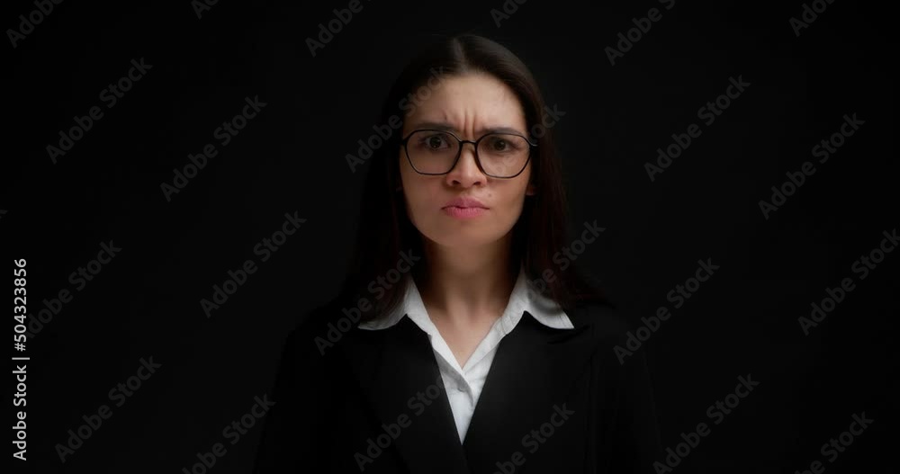 Angry brunette with glasses, dressed in business clothes,points her index finger at the camera,chooses you.Business lady gestures to keep her mouth shut, keep secrets, not tell anyone.Black background Angry brunette with glasses, dressed in business clothes,points her index finger at the camera,chooses you.Business lady gestures to keep her mouth shut, keep secrets, not tell anyone.Black background