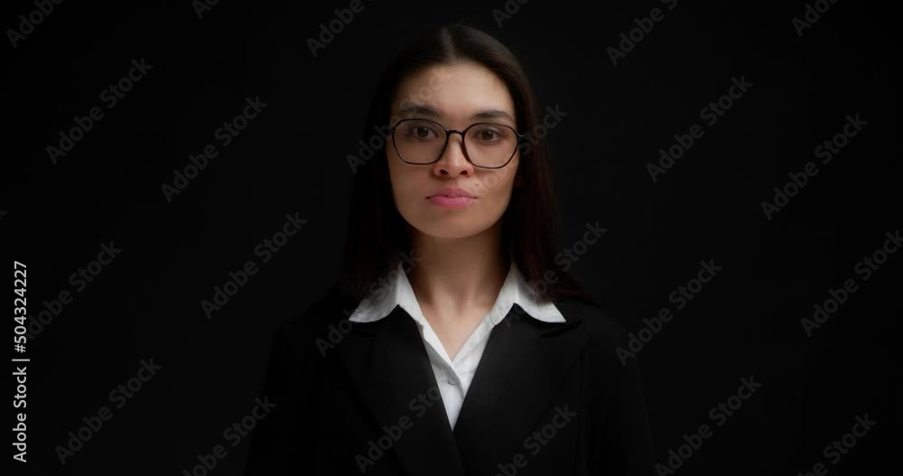 Angry brunette with glasses, dressed in business clothes,points her index finger at the camera,chooses you.Business lady gestures to keep her mouth shut, keep secrets, not tell anyone.Black background Angry brunette with glasses, dressed in business clothes,points her index finger at the camera,chooses you.Business lady gestures to keep her mouth shut, keep secrets, not tell anyone.Black background