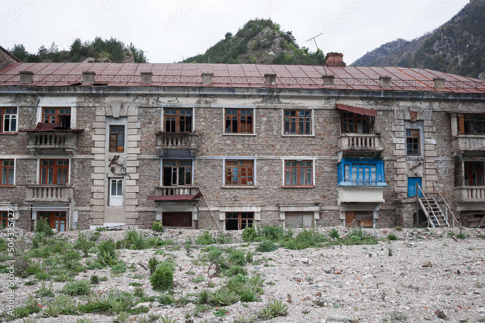 Old abandoned building with ruined balconies and crashed windows . Abandoned mining village , North Ossetia-Alania , Sadon , Russia