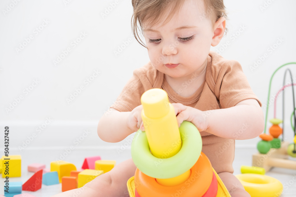 cute baby girl playing with pyramid and wooden toys at home. early children development cute baby girl playing with pyramid and wooden toys at home. early children development