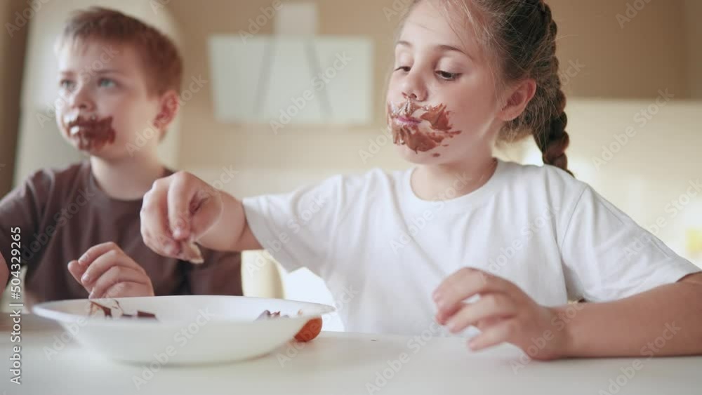 baby boy and girl eat chocolate. dirty little baby kids in the kitchen eating chocolate in the morning. happy lifestyle family eating sweets kid dream concept. baby dirty face eating chocolate cocoa baby boy and girl eat chocolate. dirty little baby kids in the kitchen eating chocolate in the morning. happy lifestyle family eating sweets kid dream concept. baby dirty face eating chocolate cocoa