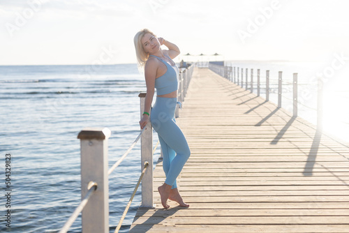 Portrait of fitness woman stretching out by the sea