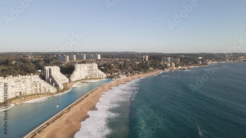 Flying over a huge swimming pool next to modern buildings at beach of Algarrobo, Chile photo