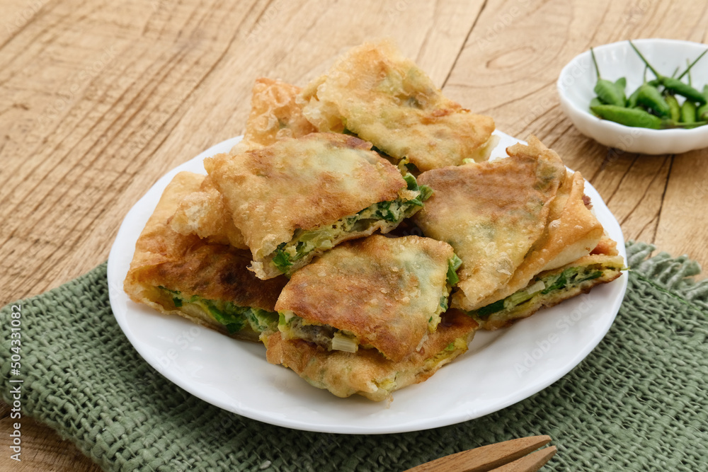 Martabak, Martabak Telor or Martabak Telur. Savory pan-fried pastry stuffed with egg, meat and spices. Martabak Telur is one of Indonesia street food. Served on white plate.
Martabak, Martabak Telor or Martabak Telur. Savory pan-fried pastry stuffed with egg, meat and spices. Martabak Telur is one of Indonesia street food. Served on white plate.