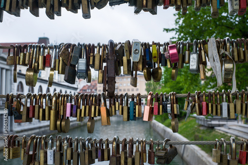 locks fixed on the railing of the bridge over the river as a symbol of eternal love