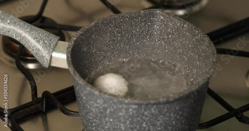 Boiled egg in grey pot take off